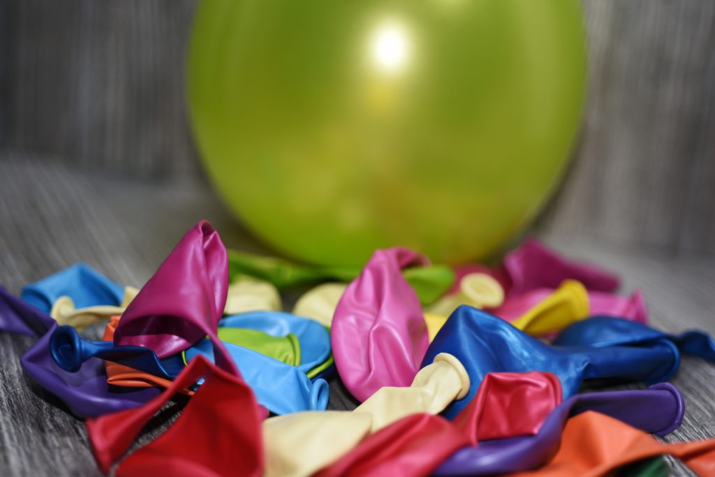 Close-up of coloured, deflated balloons on a wooden table